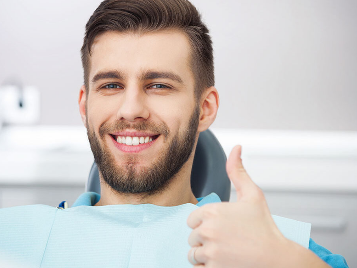 Smiling man giving a thumbs up after a preventive dental check-up.