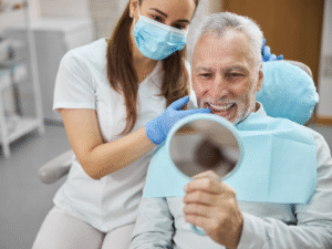 Woman smiling and holding a dental implant model, showing proper care and healing after implant surgery at Bay of Isles Dental