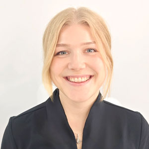 Niina smiling in a professional headshot wearing dental clinic attire.