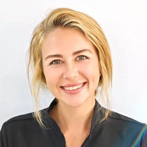 Teddie smiling in a professional headshot wearing dental clinic attire.