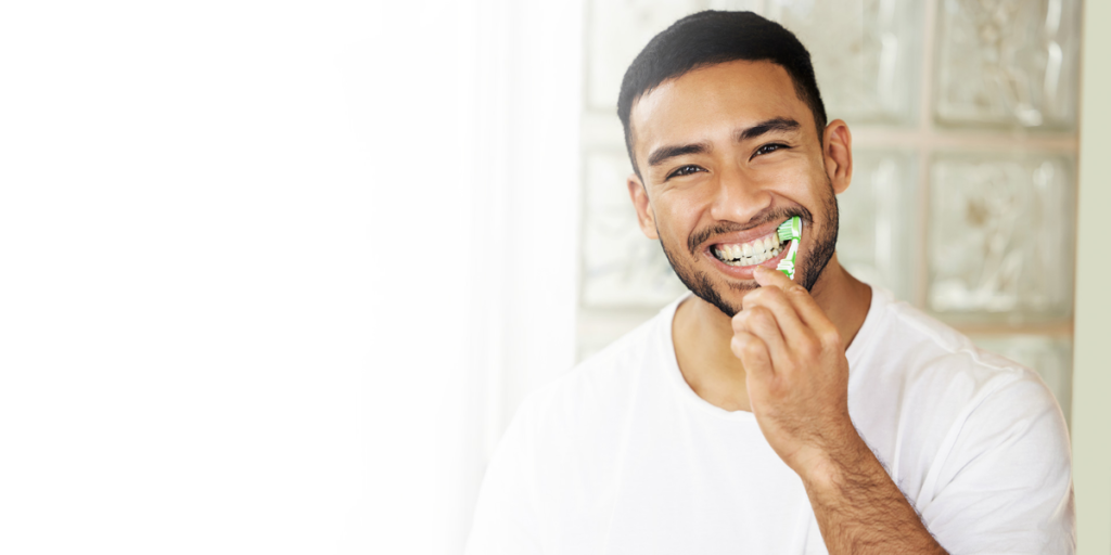 man brushing teeth demonstrating proper oral hygiene routine